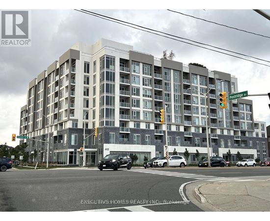 A multi-story building with a grey facade and a sign that reads "REALTOR" on the top left corner.