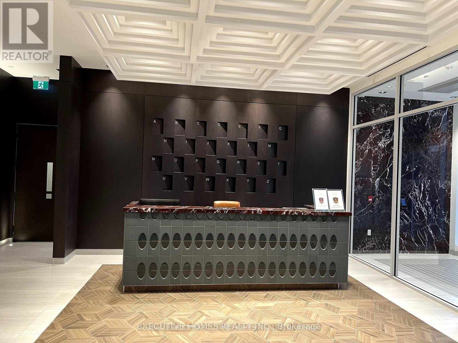 A reception area with a dark brown wall and a grey reception desk.