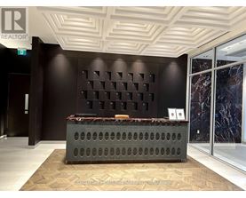 A reception area with a dark brown wall and a grey reception desk.