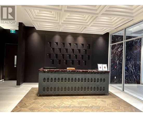 A reception area with a dark brown wall and a grey reception desk.