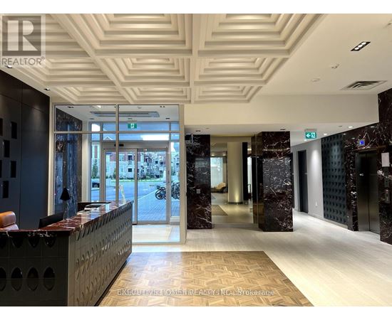 The image shows a well-lit, modern office lobby with a reception desk and a marble floor.