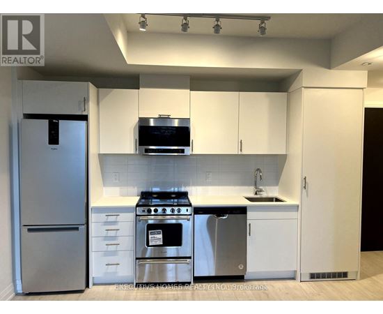 A modern kitchen with white cabinets and stainless steel appliances.