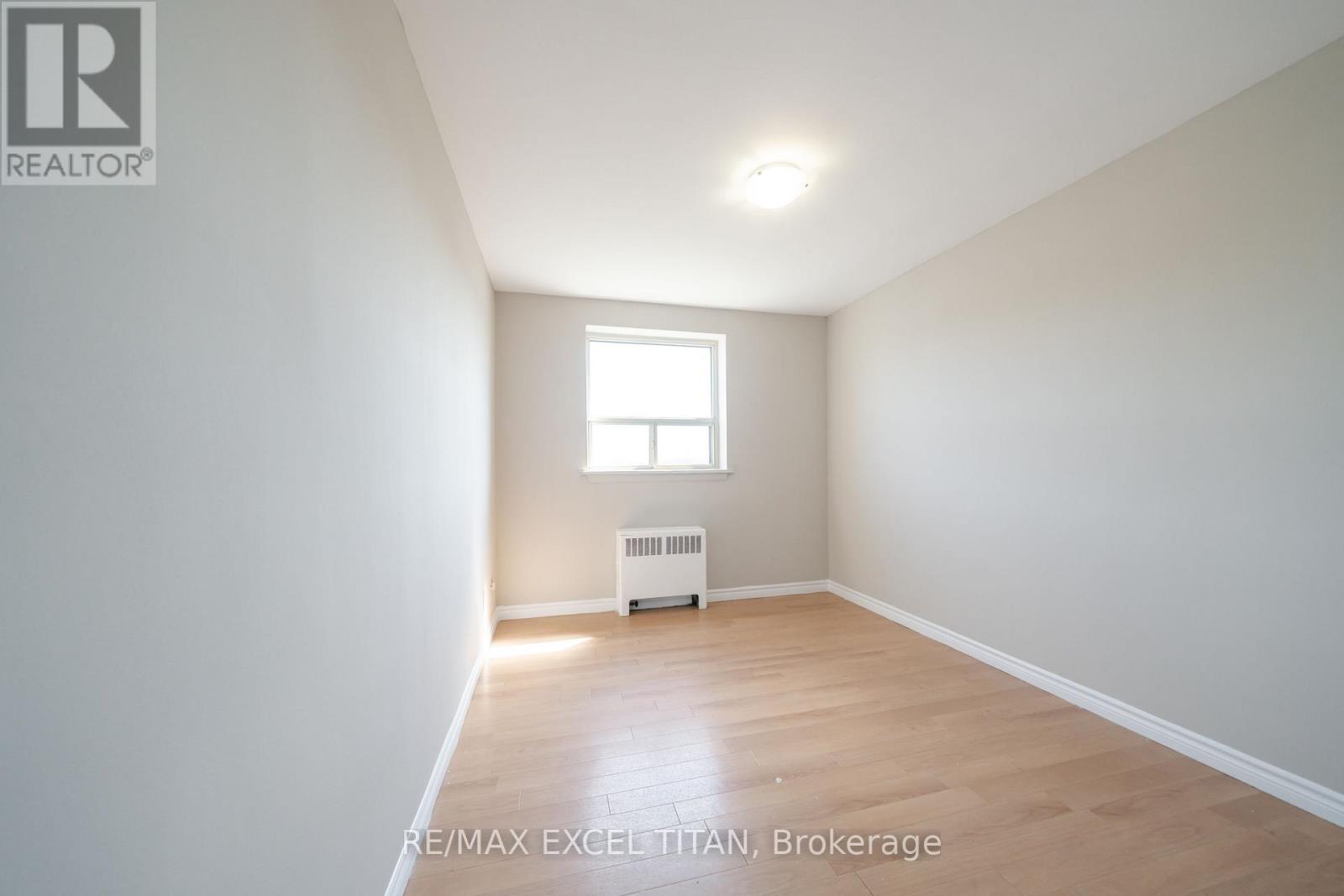 A spacious room with a window and a radiator.