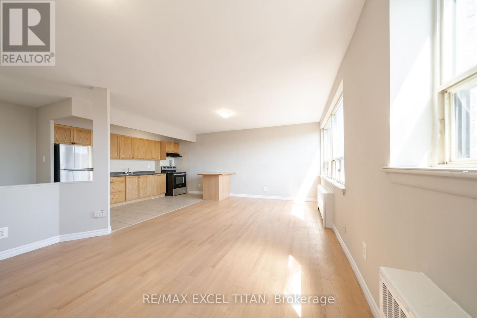 A spacious living room with wooden floors and white walls.