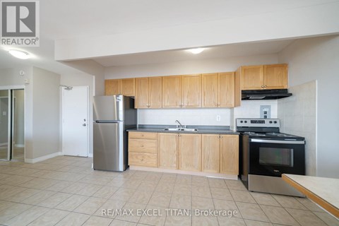A kitchen with a refrigerator, oven, and microwave.
