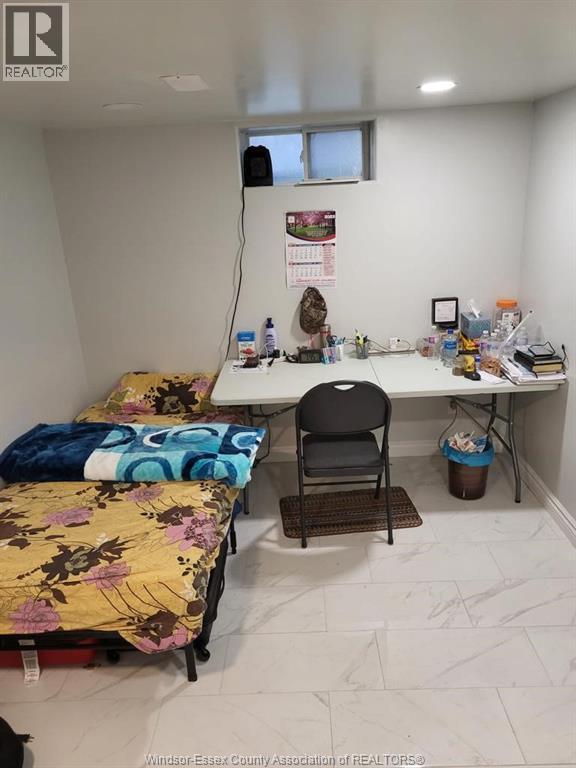 A room with a bed, desk, and chair.