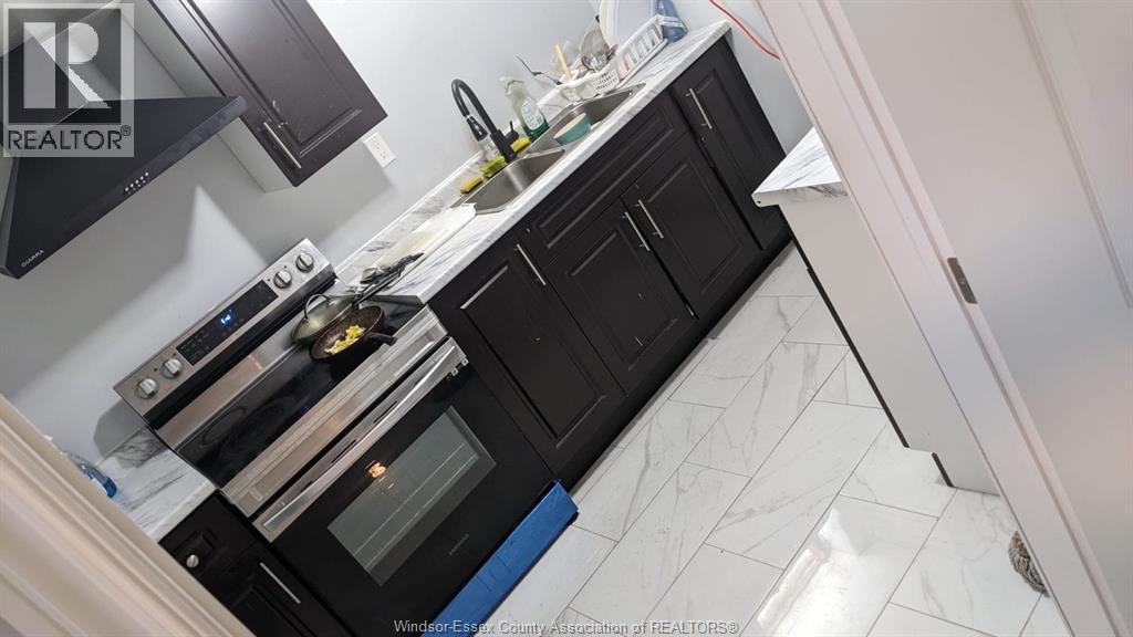 A kitchen with black cabinets and a white countertop.
