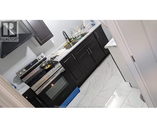 A kitchen with black cabinets and a white countertop.
