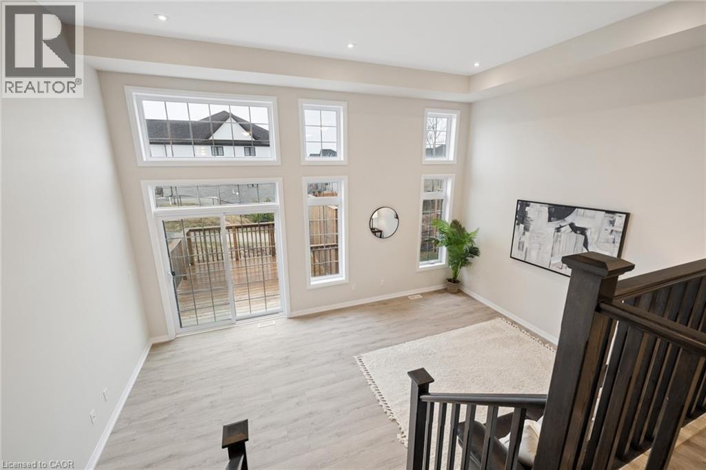 A living room with a large window and a view of a house across the way.
