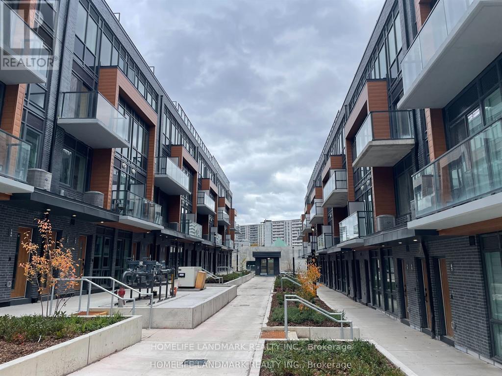 A modern apartment complex with a central walkway and landscaped areas.