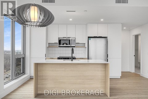 A modern kitchen with a wooden counter and a large window.