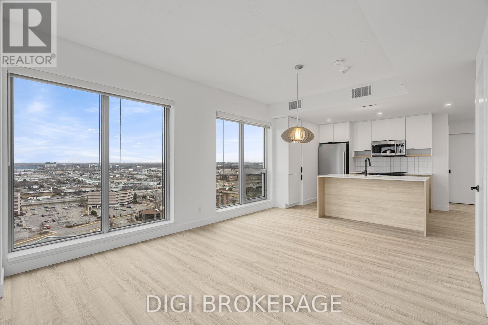 A spacious room with a view of the cityscape through large windows.