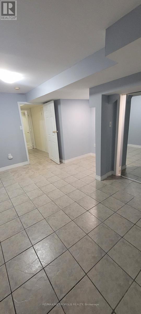 A room with a tiled floor and a doorway leading to another room.