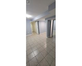 A room with a tiled floor and a doorway leading to another room.
