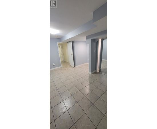 A room with a tiled floor and a doorway leading to another room.