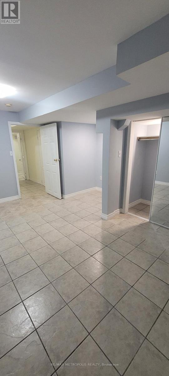 A spacious room with tile flooring and white walls.