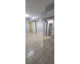 A spacious room with tile flooring and white walls.
