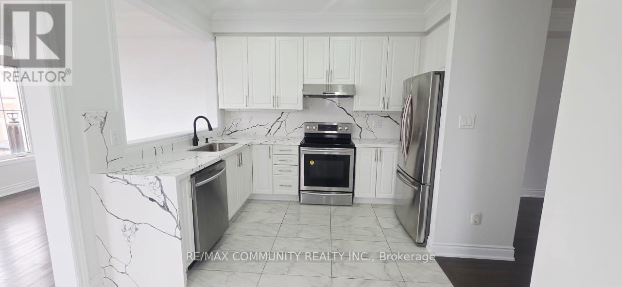 A kitchen with white cabinets and marble countertops.