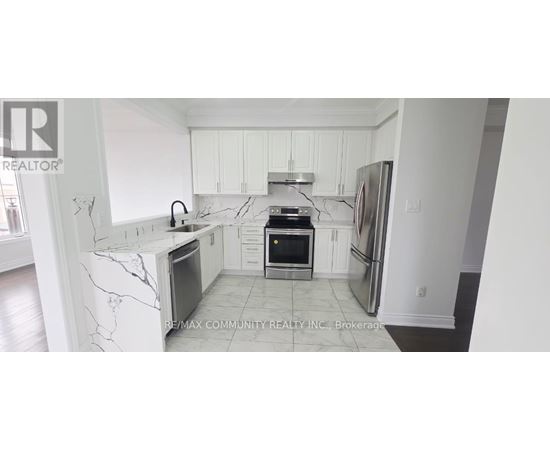 A kitchen with white cabinets and marble countertops.