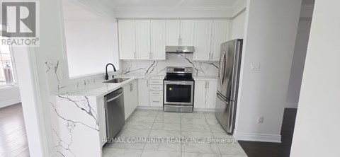A kitchen with white cabinets and marble countertops.