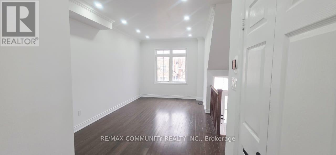 A spacious room with wooden floors and white walls.