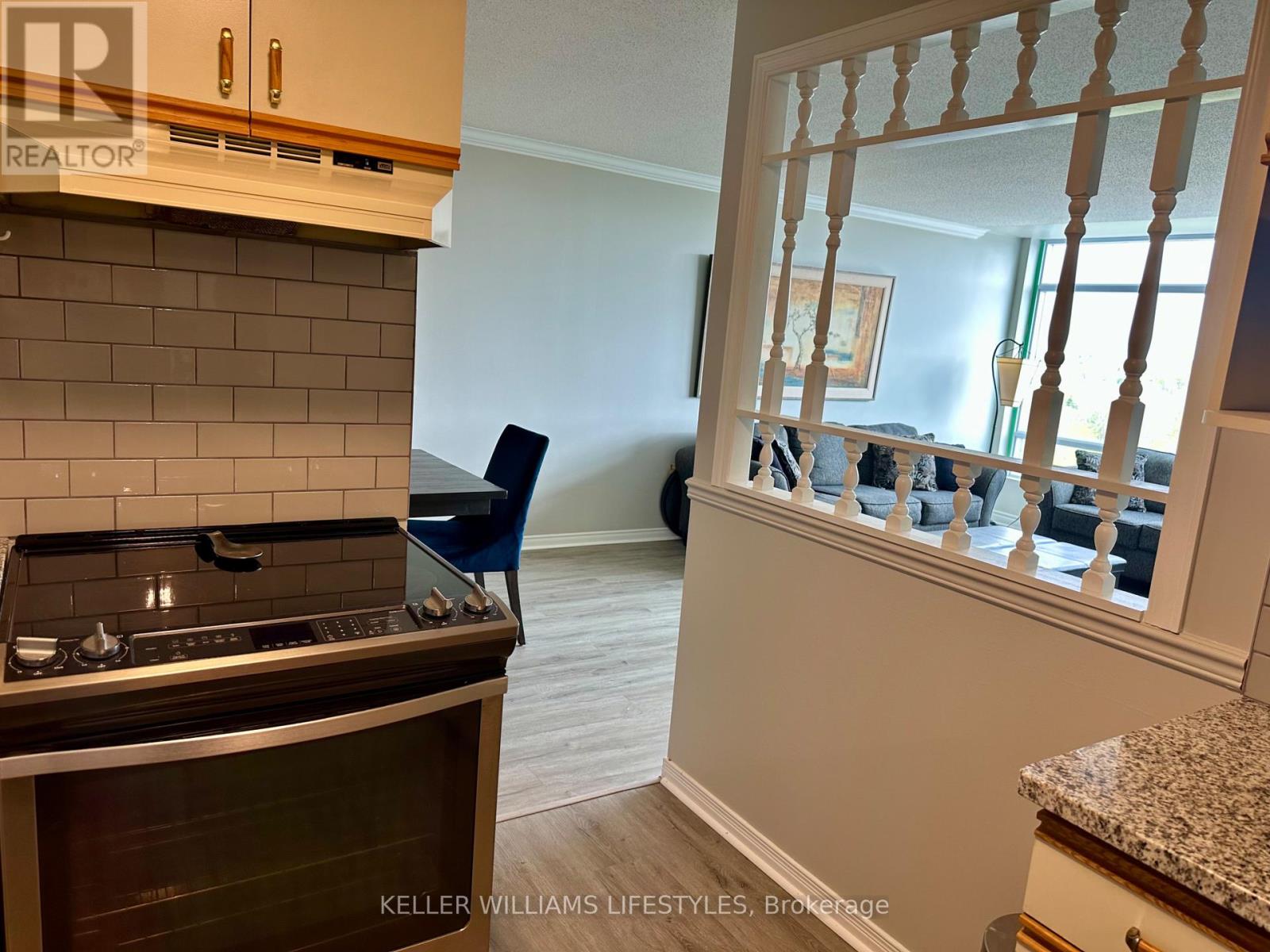 A kitchen with a stove top oven and a chair.