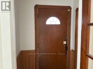 A brown door with a glass window in the middle.