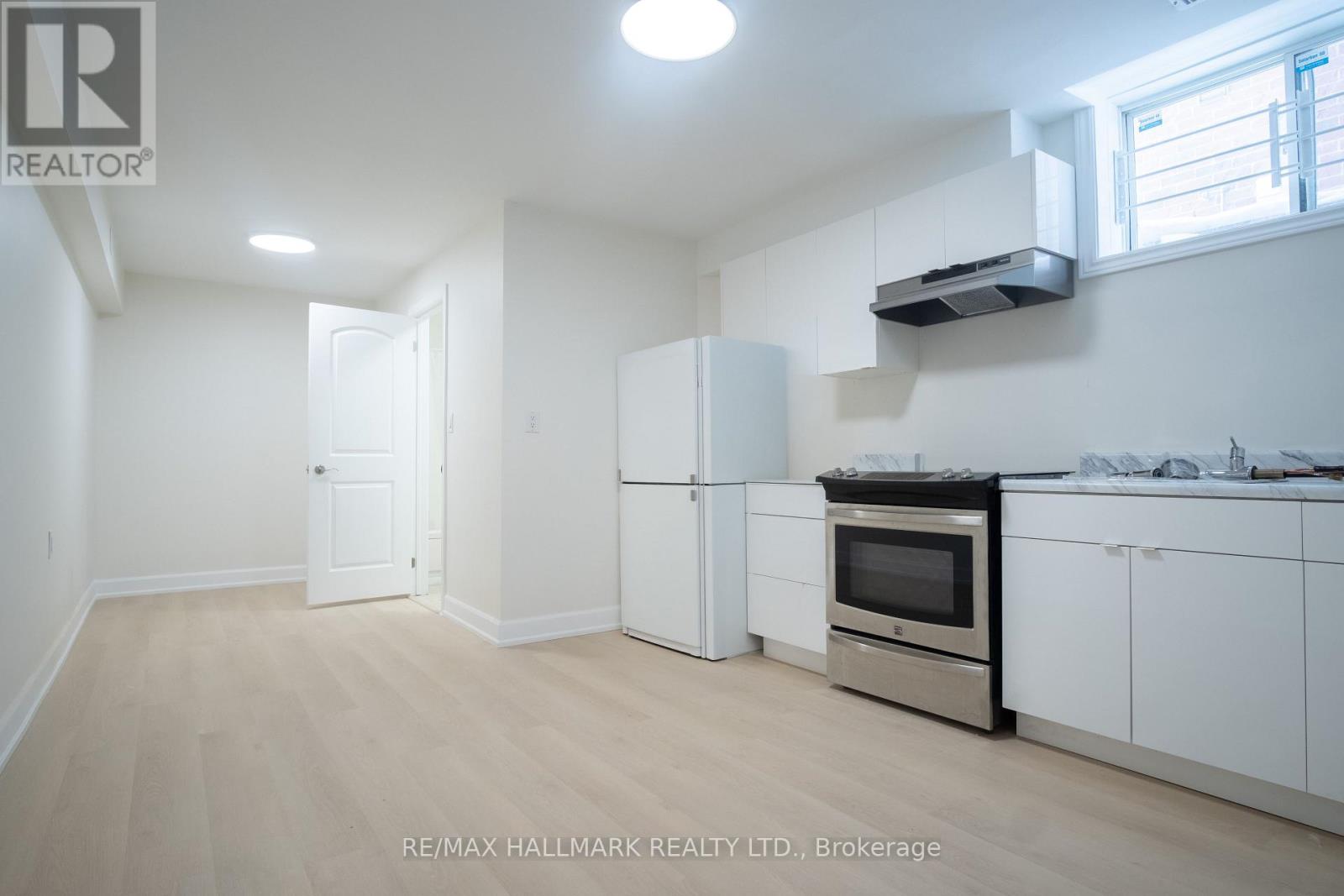 A kitchen with white appliances and cabinets is for sale.