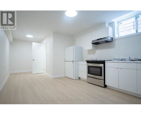A kitchen with white appliances and cabinets is for sale.