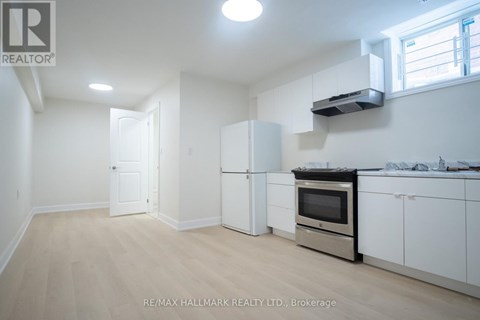A kitchen with white appliances and cabinets is for sale.