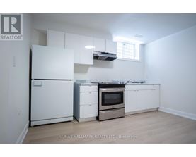 A white kitchen with a fridge, oven, and microwave.
