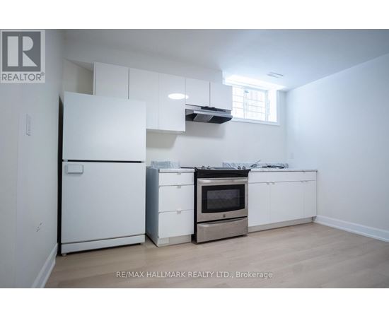 A white kitchen with a fridge, oven, and microwave.