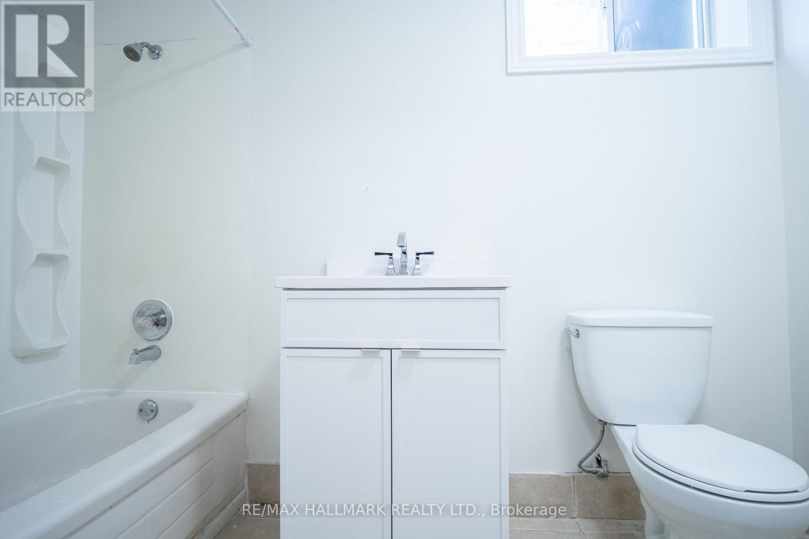 A white bathroom with a toilet, sink and bathtub.
