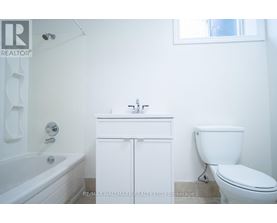 A white bathroom with a toilet, sink and bathtub.