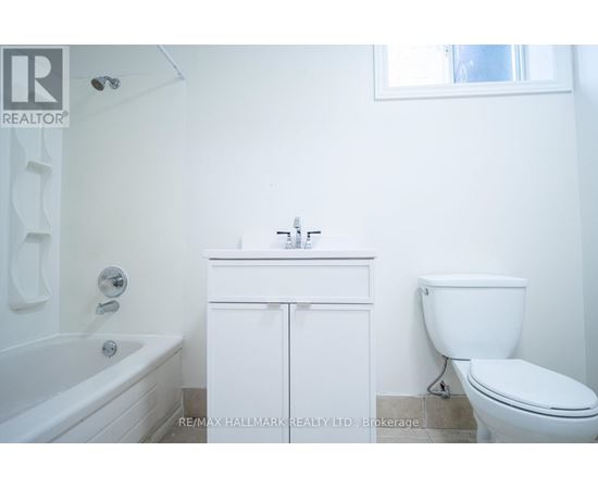 A white bathroom with a toilet, sink and bathtub.