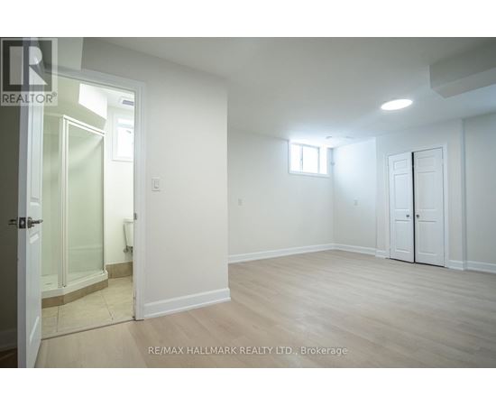 A spacious room with a door, a window, and a glass door leading to a balcony.