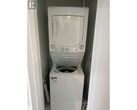 A white dryer is in a small space.