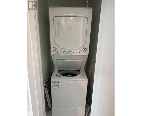 A white dryer is in a small space.