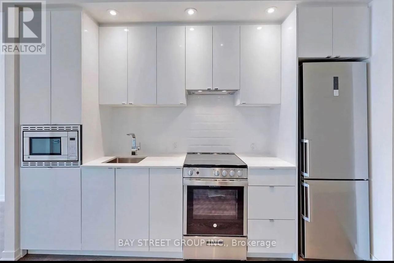 A modern kitchen with white cabinets and appliances.