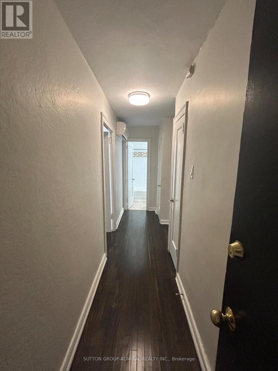 A hallway with a black door and white walls.