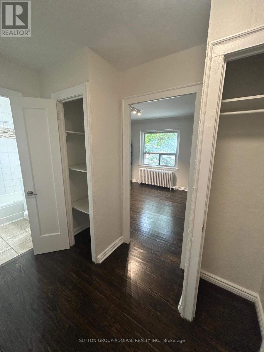 A room with white walls and dark wood floors.