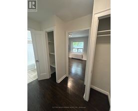 A room with white walls and dark wood floors.