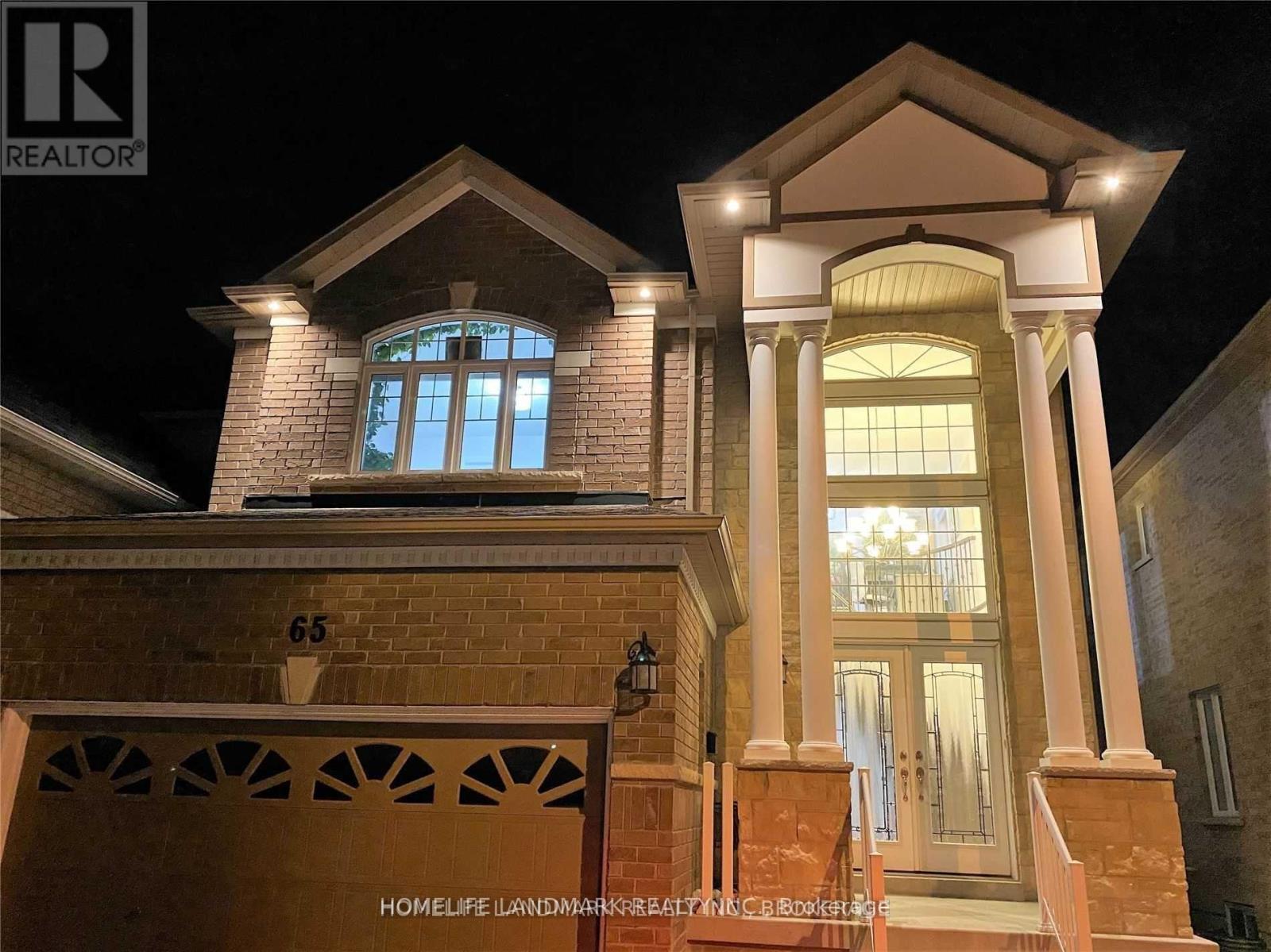A house with a lit up entrance and a sign that says "65".