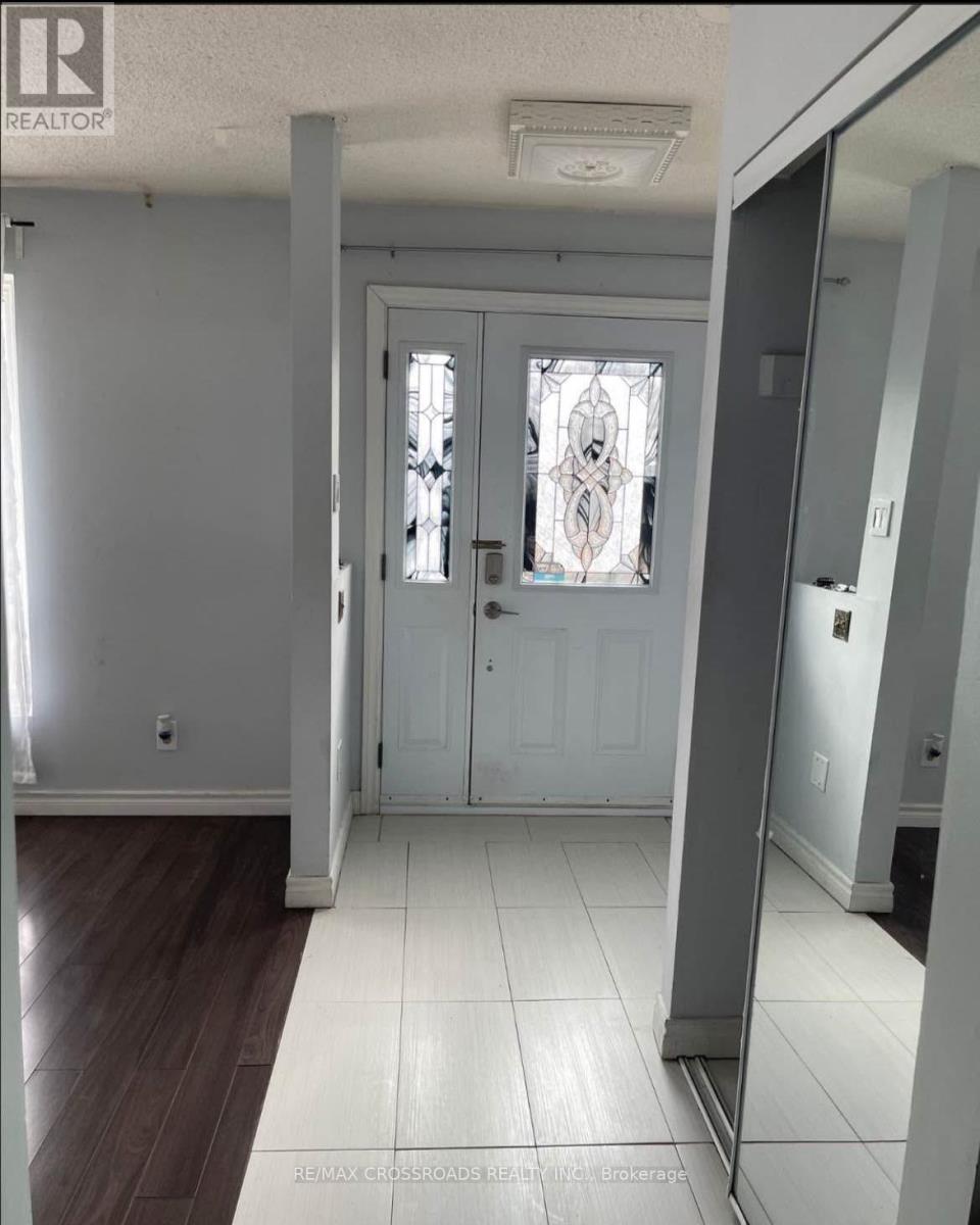 A hallway with a wooden floor and a white door with a stained glass window.