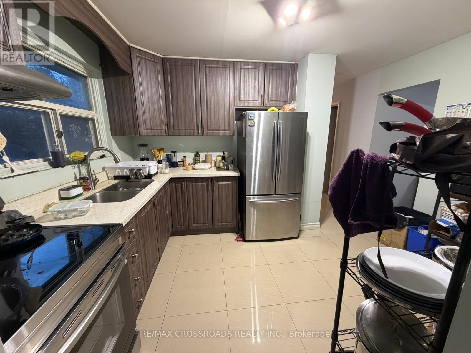 A kitchen with a stove top oven, sink, and refrigerator.