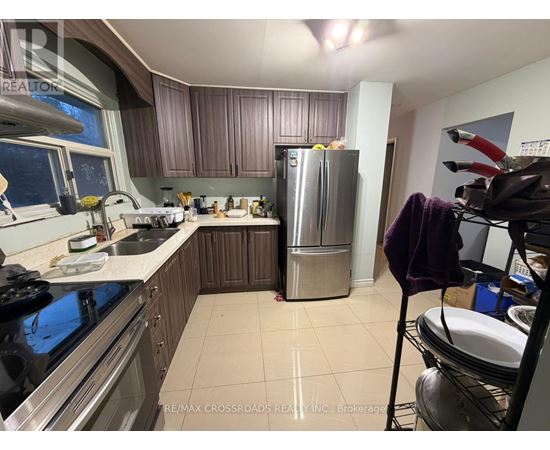 A kitchen with a stove top oven, sink, and refrigerator.