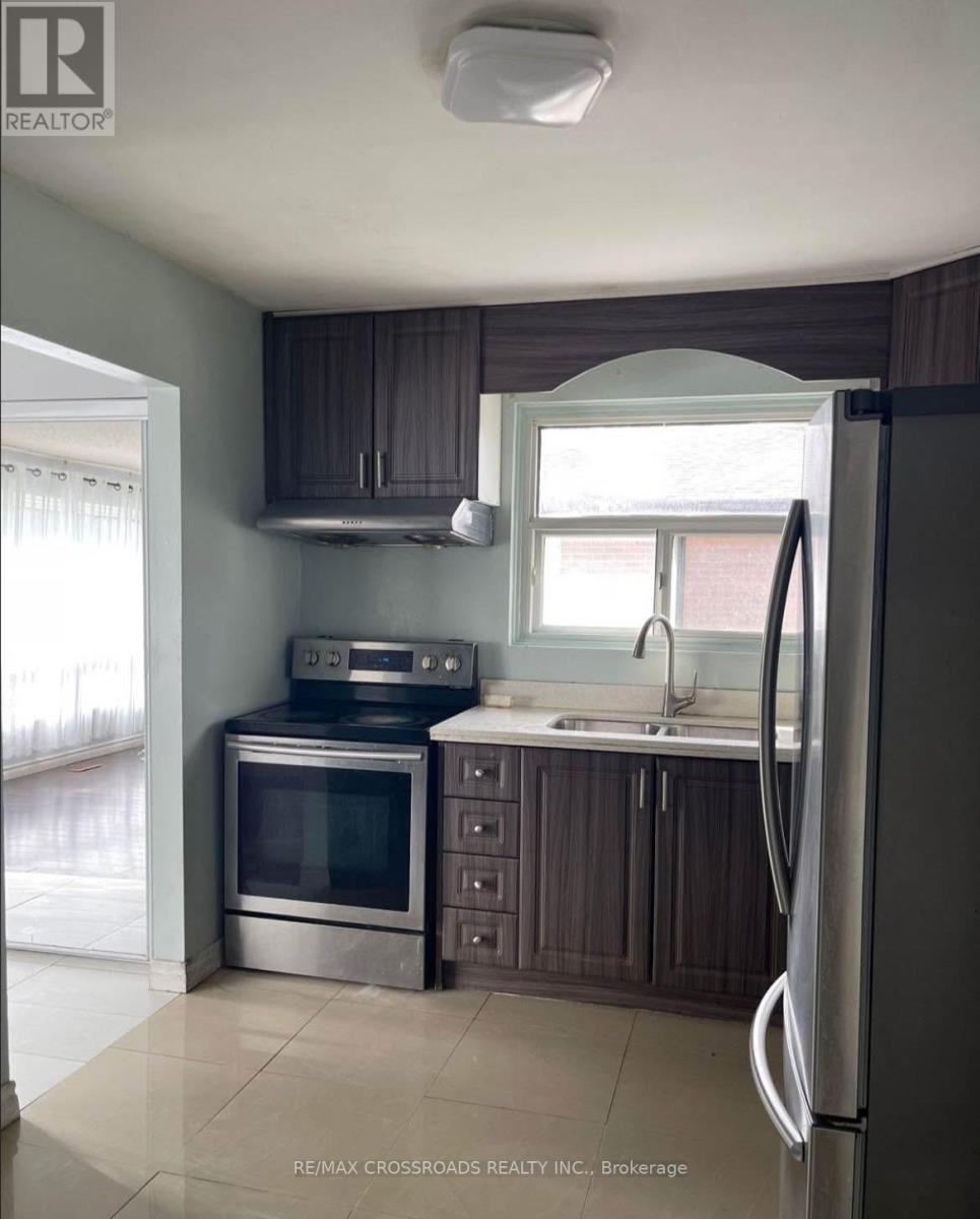 A kitchen with a refrigerator, oven, and microwave.