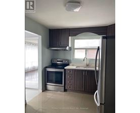 A kitchen with a refrigerator, oven, and microwave.