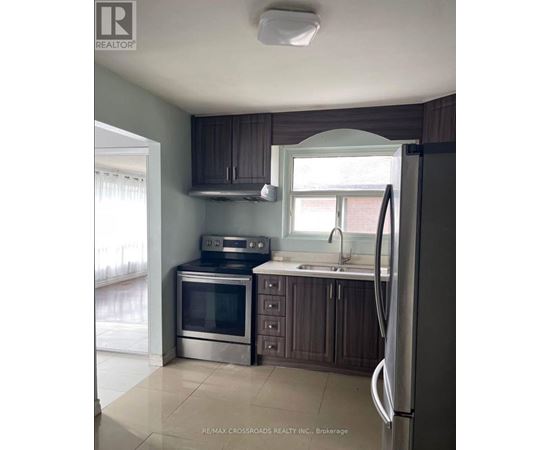 A kitchen with a refrigerator, oven, and microwave.