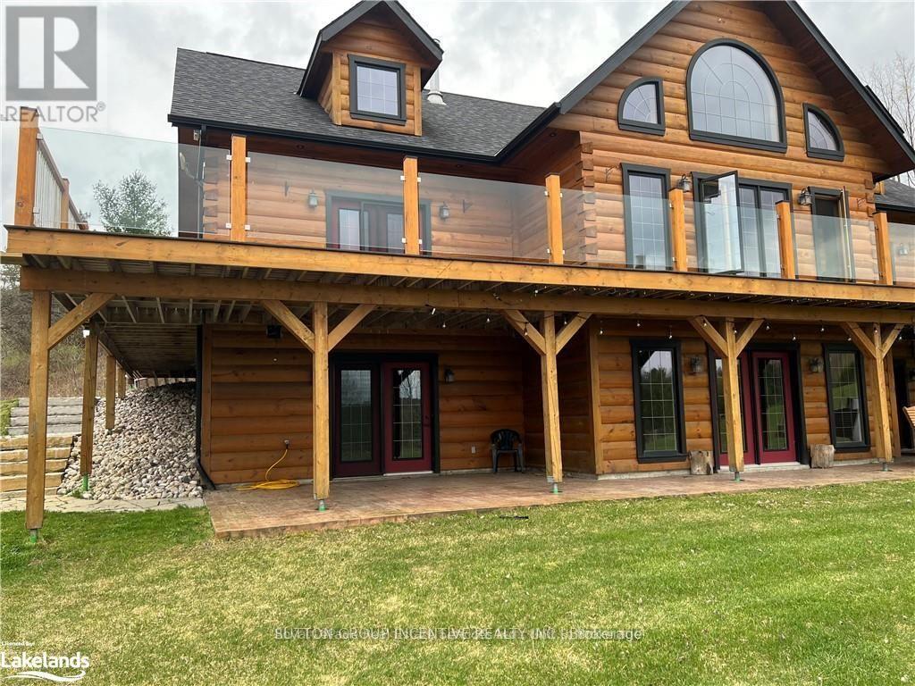 A large wooden house with a balcony and a stone wall.